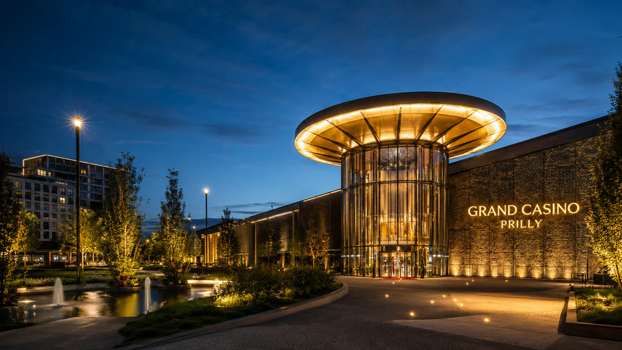 Grand Casino Prilly illuminé la nuit, fontaines et entrée vitrée — taxi Lausanne–Prilly pour vos soirées