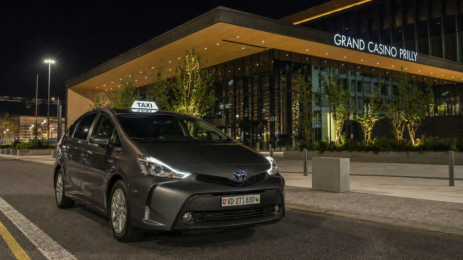 Taxi Toyota Prius+ TAXI 624 devant l'entrée du Grand Casino Prilly — dépose et retour de soirée, prix ferme